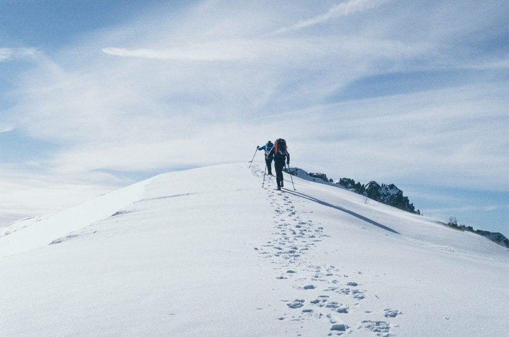 Trekkers making their way through snowy trails on Mount Kilimanjaro's upper slopes.